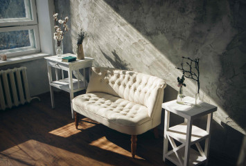 Sofa mit Beistelltischen vor einem Fenster