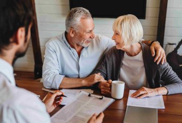 Ehepaar bei einer persönlichen Beratung zum Immobilienverkauf mit einem Makler